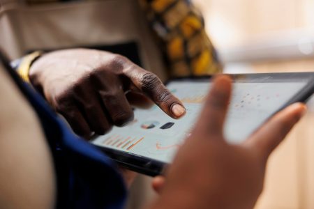 La main d'un ouvrier d'entrepôt montrant les statistiques d'inventaire sur la tablette